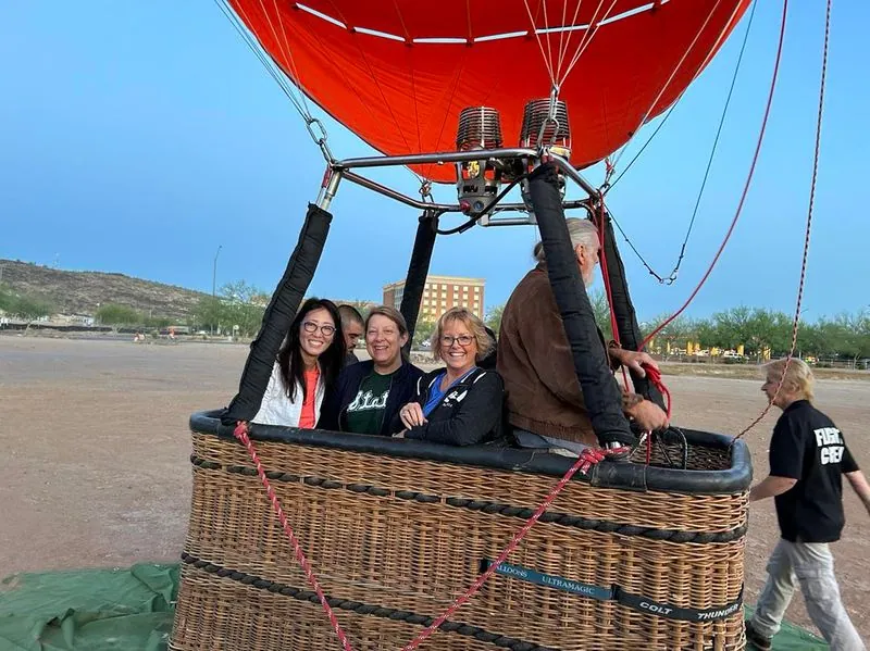 Retreat guests in a hot-air balloon basket at sunrise