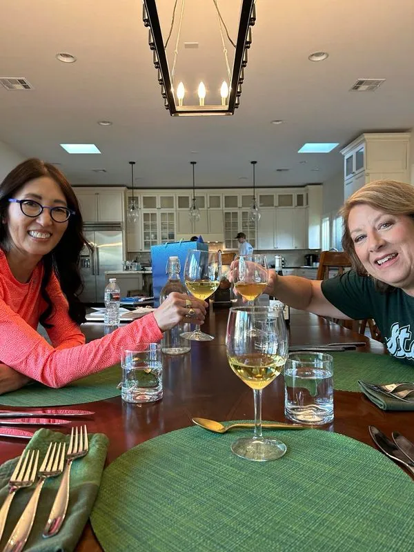 Retreat guests toasting at a private chef dinner